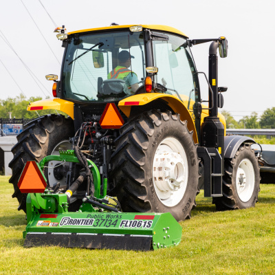 A Public Works tractor pulls a new mower attachment.