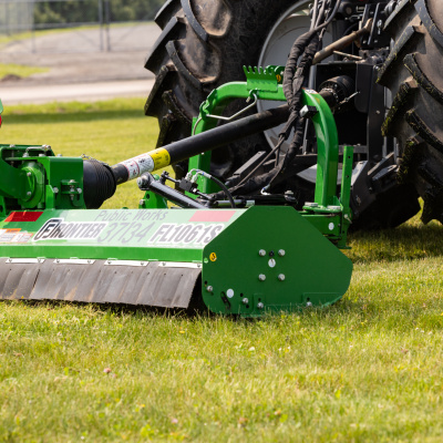 A new mower attachment is pulled behind a tractor.