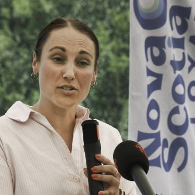 Geena Luckett holding a microphone at a podium