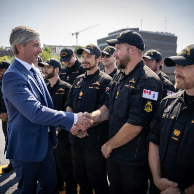 Premier Tim Houston shakes hands with members of the Canadian military.