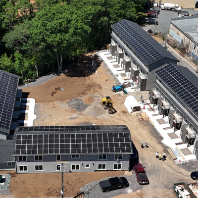 aerial photo of four buildings with solar panels on the roofs